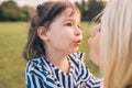 Portrait of happy cute little girl playing with her pretty mother in the park. Loving mother and daughter spend time together in Royalty Free Stock Photo