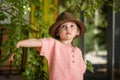 Portrait of happy cute little girl in rural style brown hat and muslin clothes on green background in a summer day Royalty Free Stock Photo