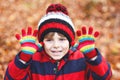 Portrait of happy cute little kid boy with autumn leaves background in colorful clothing. Funny child having fun in fall Royalty Free Stock Photo