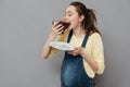 Portrait of a happy cute pregnant woman biting chocolate cake Royalty Free Stock Photo