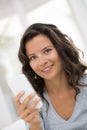 Portrait of happy cute woman with mobile phone sitting on couch Royalty Free Stock Photo