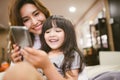 Portrait Happy Daughter playing smartphone with her mother. Royalty Free Stock Photo