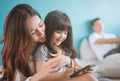 Portrait Happy Daughter playing smartphone with her mother. Royalty Free Stock Photo