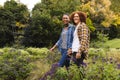 Portrait of happy diverse couple holding hands, walking in garden, copy space Royalty Free Stock Photo