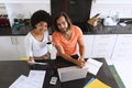 Portrait of happy diverse couple sitting in kitchen using laptop and paying bills Royalty Free Stock Photo