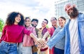 Portrait of happy diverse large group of multicultural friends holding hands making high five stacking them together outdoor. Royalty Free Stock Photo