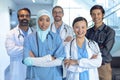 Happy medical team of doctors standing with arm crossed and looking at camera in the hospital