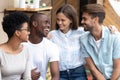 Portrait of happy diverse millennial friends hug at meeting