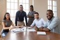 Multiethnic smiling employees gather at boardroom meeting