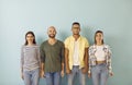 Multiracial group of happy, smiling young people standing against blue studio background Royalty Free Stock Photo