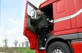 Portrait of happy driver getting into cab of truck