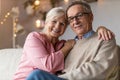 Happy elderly couple relaxing together on the sofa at home Royalty Free Stock Photo