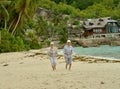 Portrait of happy elderly couple running on tropical beach Royalty Free Stock Photo