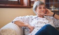 Portrait happy elderly woman smiling sitting on sofa at home enjoying retirement Royalty Free Stock Photo