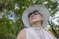 Portrait of a happy elderly woman 65 - 70 years old in a straw hat on the background of nature, closeup Royalty Free Stock Photo