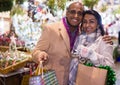 Portrait of happy elegant couple with gift bags at new year fair Royalty Free Stock Photo