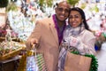 Portrait of happy elegant couple with gift bags at new year fair Royalty Free Stock Photo