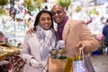 Portrait of happy elegant couple with gift bags at new year fair Royalty Free Stock Photo