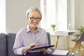 Happy, beautiful, smiling, mature business lady in glasses using modern tablet computer Royalty Free Stock Photo