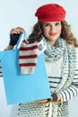 Happy woman showing blue shopping bag with bought sweater Royalty Free Stock Photo