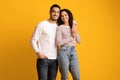 Portrait of happy embracing middle eastern couple posing over yellow background Royalty Free Stock Photo