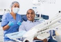 Happy man with professional woman stomatologist in dental clinic