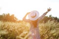 Portrait of happy and enjoying young woman on a meadow on a sunny summer day. Cheerful girl on sunset. Lifestyle and happiness