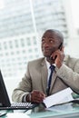 Portrait of a happy entrepreneur making a phone call while reading a document Royalty Free Stock Photo