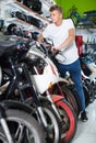 Portrait of male motorcyclist looking on the bike in the store