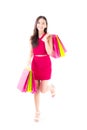 Portrait of a happy excited asian woman in red dress standing and holding colorful shopping bags. Royalty Free Stock Photo