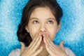Portrait of a happy excited girl open mouth keeping hands at her face isolated over blue background Royalty Free Stock Photo