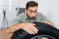 Portrait of happy excited man customer examining brand and product characteristics while buying new tires in auto Royalty Free Stock Photo