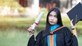 Portrait of happy and excited of young Asian female university graduate wears graduation gown and hat celebrates with degree in un Royalty Free Stock Photo