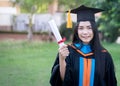 Portrait of happy and excited of young Asian female university graduate wears graduation gown and hat celebrates with degree in un Royalty Free Stock Photo