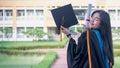 Portrait of happy and excited of young Asian female university graduate wears graduation gown and hat celebrates with degree in un Royalty Free Stock Photo