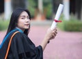 Portrait of happy and excited of young Asian female university graduate wears graduation gown and hat celebrates with degree in un Royalty Free Stock Photo