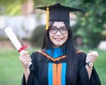 Portrait of happy and excited of young Asian female university graduate wears graduation gown and hat celebrates with degree in un Royalty Free Stock Photo