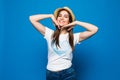 Close up portrait of a happy excited young woman in beach hat happy looking at camera isolated over blue background Royalty Free Stock Photo