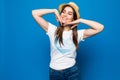 Close up portrait of a happy excited young woman in beach hat happy looking at camera over blue background Royalty Free Stock Photo