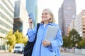 Portrait of happy, excited young woman, standing in big city with smartphone and laptop, looking amazed and inspired Royalty Free Stock Photo