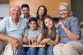 Portrait of happy extended family playing chess in living room Royalty Free Stock Photo