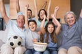 Portrait of happy extended family watching tv in living room Royalty Free Stock Photo