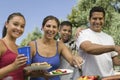 Portrait Of Happy Family Around The Grill At Picnic