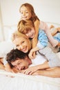 Portrait, happy and family on bed with kids, parents and play for bonding in bedroom. Couple, children and smiles for Royalty Free Stock Photo