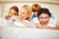 Portrait, happy and family in bed with kids, parents and play for bonding in bedroom. Couple, children and smiles for Royalty Free Stock Photo