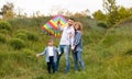 Portrait of happy family with bright kite in countryside Royalty Free Stock Photo