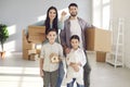 Portrait of happy family with children showing keys to their new home on moving day Royalty Free Stock Photo