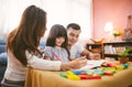 Portrait of happy family daughter girl is learning drawing book together with parent Royalty Free Stock Photo