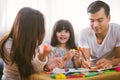 Portrait of happy family daughter girl is learning to use colorful play dough blocks toy together with parent. Royalty Free Stock Photo