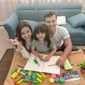 Portrait of happy family daughter and parent drawing and reading together. Royalty Free Stock Photo